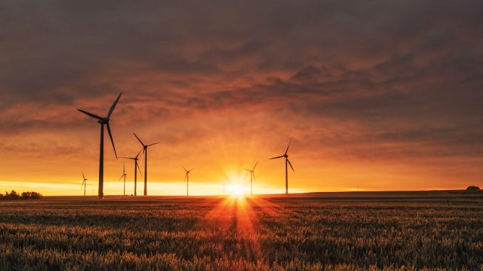 Photo by Karsten Würth windmill on grass field during golden hour