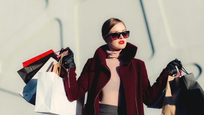 Photo by freestocks photo of woman holding white and black paper bags