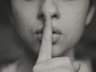 grayscale photo of woman doing silent hand sign