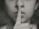grayscale photo of woman doing silent hand sign