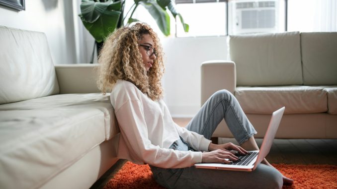 Photo by Thought Catalog woman sitting on floor and leaning on couch using laptop