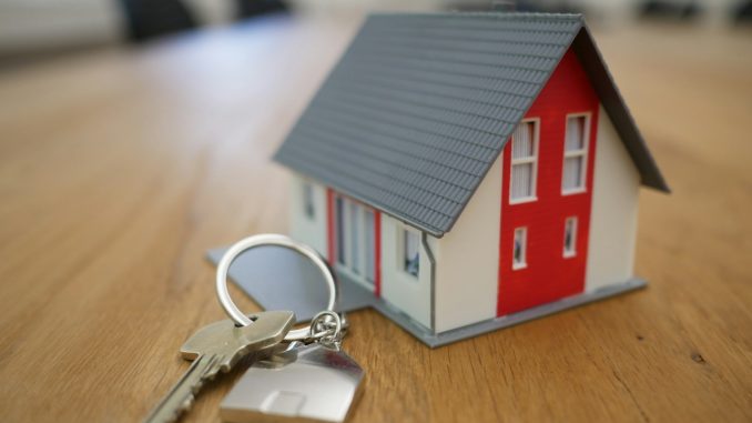 Photo by Tierra Mallorca white and red wooden house miniature on brown table