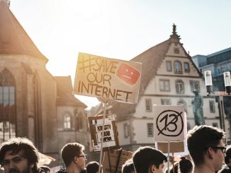 person holding save our internet signage during daytime