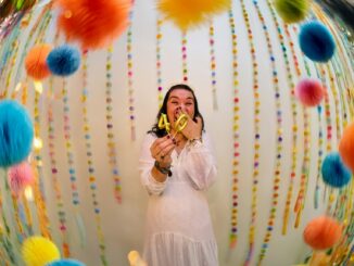 Woman celebrating with "40" balloons and colorful decorations