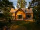 a small wooden house surrounded by trees on a sunny day